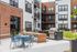 Modern apartment courtyard featuring stylish outdoor seating, dual stainless steel grills, and elegant landscaping.