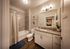 Elegant bathroom featuring a modern vanity, large mirror, and sleek tile accents, creating a serene spa-like atmosphere.