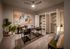 Elegant home office with abstract art, lush greenery, and stylish glass-top desk, complemented by a spacious open closet.