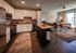 Modern apartment kitchen with sleek stainless steel appliances, spacious white cabinetry, and a cozy open living area featuring stylish decor and a large window for natural light.
