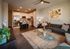 Contemporary open-plan living and kitchen area with elegant decor, featuring a sleek sofa, vibrant artwork, and a stylish breakfast bar.