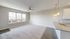 Bright, modern living space with large windows, elegant hanging lights, and a sleek open kitchen design with pristine counter space.