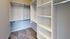 Spacious walk-in closet with custom shelving and ample hanging space, perfect for organized living.