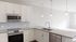 Modern kitchen with sleek countertops, stainless steel appliances, and elegant pendant lighting, offering a bright and inviting space.