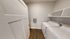 Modern laundry room with sleek appliances and elegant wooden flooring, offering convenience and style.