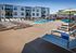 Modern apartment community with a luxurious outdoor swimming pool, surrounded by stylish sun loungers and vibrant seating areas for ultimate relaxation.