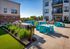Chic outdoor patio with modern seating, lush greenery, and built-in BBQ grills, perfect for entertaining.