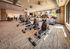 Modern fitness center with state-of-the-art exercise equipment, bright spacious layout, and floor-to-ceiling windows offering vibrant views.