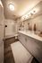 Elegant bathroom with modern double vanity, stylish lighting, and a cozy bathtub. Featuring chic wood flooring.