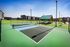 Luxurious apartment community with vibrant green lawns and modern pickleball court, perfect for an active lifestyle.