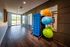 Bright and modern exercise room with yoga mats, exercise balls, and large windows offering scenic views.