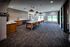 Modern and spacious communal area with a sleek kitchenette, stylish pendant lighting, and large windows providing natural light, complemented by comfortable seating.