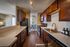 Bright and modern kitchen with sleek dark wood cabinets, stainless steel appliances, and a spacious layout overlooking a cozy dining area.
