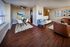 Chic apartment living area with stylish hardwood floors, cozy seating with a bright dining space.