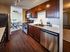 Modern kitchen with sleek dark wood cabinetry, stainless steel appliances, and an inviting dining area perfect for entertaining.