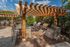 Chic outdoor space featuring a wooden pergola with grills and stylish bar seating, perfect for entertaining.
