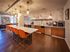 Luxurious clubhouse kitchen space featuring modern lighting, elegant countertops, and bar stools with a cozy lounge area.