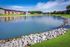 Serene apartment community with a picturesque lake view, surrounded by lush greenery and vibrant architecture.