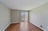 Bright and welcoming living space with elegant hardwood floors and large sliding glass doors, offering a serene view.