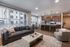 Chic open-concept apartment living room with modern kitchen, cozy seating, and abundant natural light from large windows.