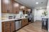 Modern kitchen featuring sleek wooden cabinetry, stainless steel appliances, and a stylish breakfast bar with vibrant decor.