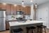 Sleek and modern kitchen with stainless steel appliances, stylish wooden cabinetry, and a chic island.
