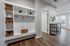 Modern and inviting apartment entrance with elegant shelving and bright natural light, creating a warm and stylish entryway.