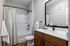 Sleek and modern bathroom featuring a stylish wooden vanity, large mirror, and contemporary fixtures.