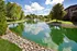 Tranquil lakeside setting with lush greenery, serene water reflection, and charming suburban homes creating a picturesque escape.