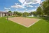 Charming outdoor volleyball court amidst lush greenery and scenic pond views, perfect for recreation and relaxation.