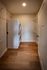 Modern laundry room featuring a stackable washer and dryer, sleek wooden flooring, and convenient shelving for optimized space utilization.