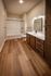 Elegant bathroom with rich wooden floors, modern fixtures, and spacious vanity, perfect for luxurious living.