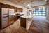 Modern open-concept kitchen with stainless steel appliances, elegant cabinetry, and expansive windows offering natural light.