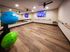 Stunning fitness studio with mirrored walls, ballet barre, exercise balls, and modern wood flooring.