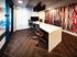 Modern conference room with sleek white marble table and colorful geometric accent wall, perfect for dynamic meetings.