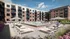 Elegant apartment community called The Vault on Main with a luxurious outdoor swimming pool, surrounded by stylish lounge chairs and vibrant gardens, offering a serene retreat for residents.