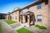Charming brick apartment community with manicured green lawns and welcoming entrance, ideal for comfortable living.