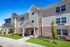 Modern apartment building with a welcoming entrance, fresh landscaping, and large windows.
