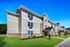 Modern apartment building with stylish siding, lush green lawn offering a perfect blend of comfort and elegance.