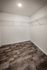 Spacious walk-in closet with modern laminate flooring and ample shelving, ideal for organized storage solutions.