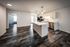 Modern open-concept apartment showcasing a sleek kitchen with stainless steel appliances, elegant lighting, and stylish wood flooring.