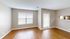 Bright, spacious living area with beautiful hardwood floors and ample natural light, perfect for modern living.
