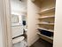 Bright bathroom with sleek vanity and ample shelving for organized storage.