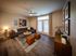 Flats at Walnut Ridge Apartments -Contemporary living room with chic decor, featuring a sleek gray sofa, modern art, and natural light from elegant French doors.