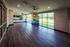 Flats at Walnut Ridge Apartments - Sunlit fitness room featuring elegant wooden floors, mirrored wall, and a vibrant mix of exercise balls with views of lush greenery through large windows.