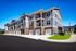 Flats at Walnut Ridge Apartments - Modern apartment complex featuring elegant architecture with spacious balconies and attached garages.