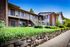 Shore Acres Apartments in Indianapolis, IN - Charming apartment complex showcasing traditional brick architecture, lush green landscaping, and a welcoming entrance with spacious balconies.