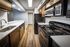 Shore Acres Apartments in Indianapolis, IN - Modern kitchen with sleek dark cabinetry, stainless steel appliances, and elegant wood flooring, providing a stylish and functional cooking space.
