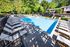Shore Acres Apartments in Indianapolis, IN - Inviting outdoor pool area surrounded by lush greenery, featuring elegant sun loungers for relaxation and leisure.