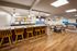 Shore Acres Apartments in Indianapolis, IN - Modern open-concept lounge and kitchen area with chic bar stools, inviting dining setup, and elegant decor accents, perfect for entertaining.